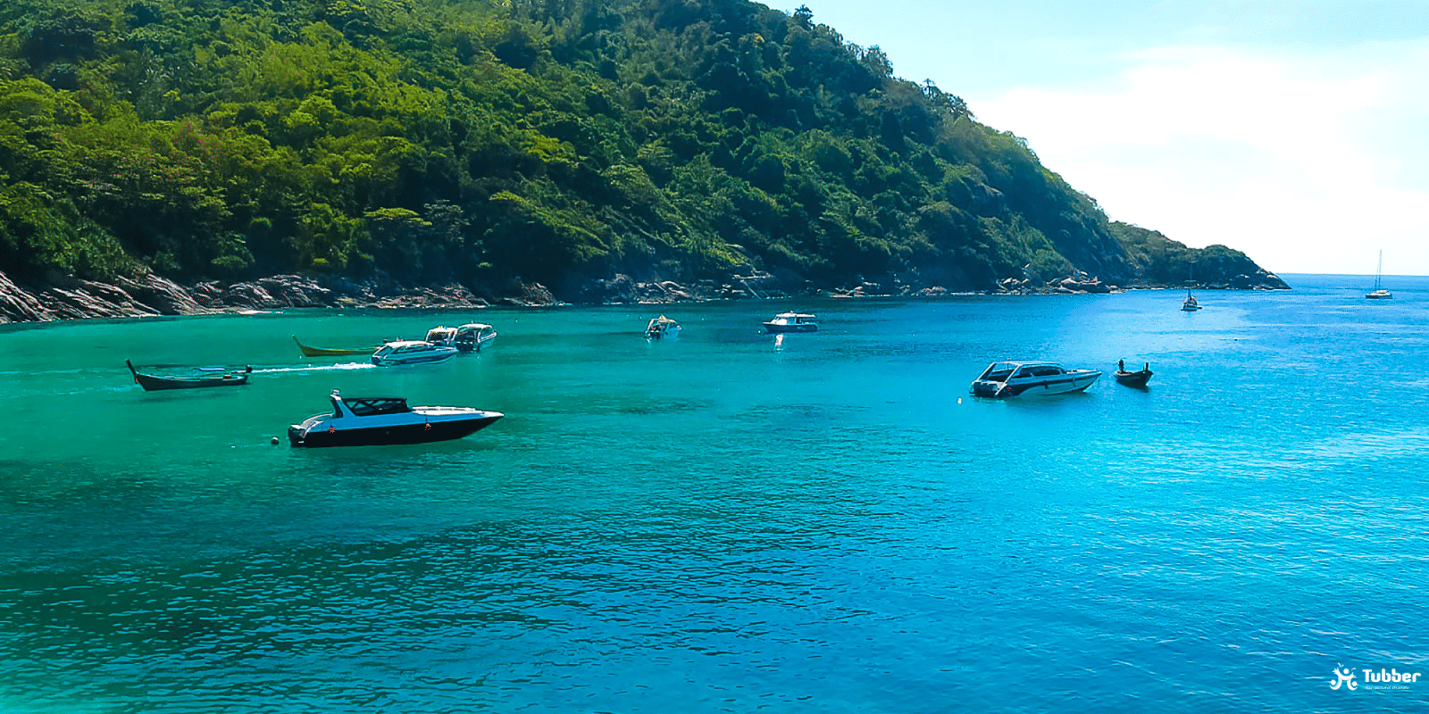 Anchored boats at Koh Racha Yai, clear blue sea and jungle coast ideal for snorkeling and diving