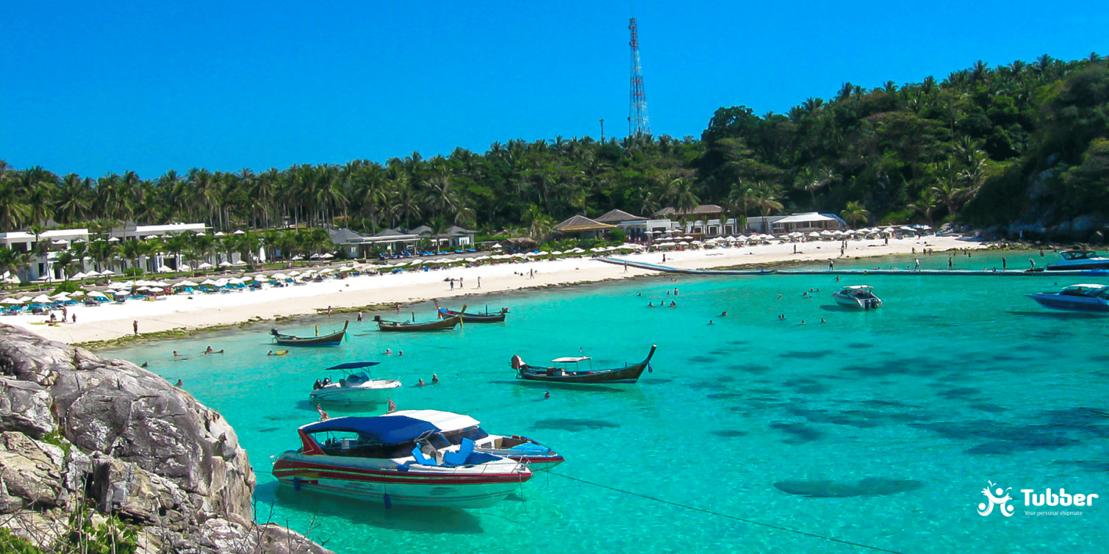 Boats anchored off the coast of Koh Racha Yai with vibrant coral reefs and a white sand beach lined with palm trees