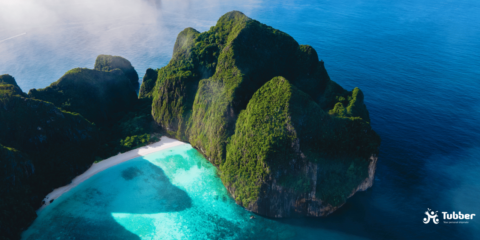 Aerial view of Maya Bay on Phi Phi Leh, surrounded by steep cliffs and crystal-clear water in a protected Thai marine reserve