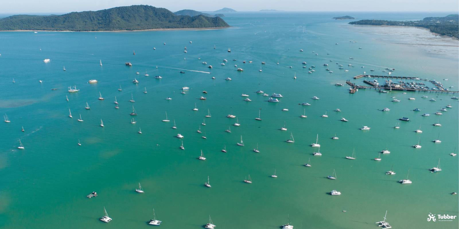 Aerial view of Yacht Haven Marina in Phuket, crowded with sailing yachts and catamarans.