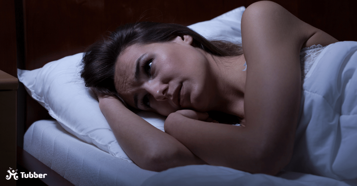 Girl laying down with eyes open annoyed not being able to sleep