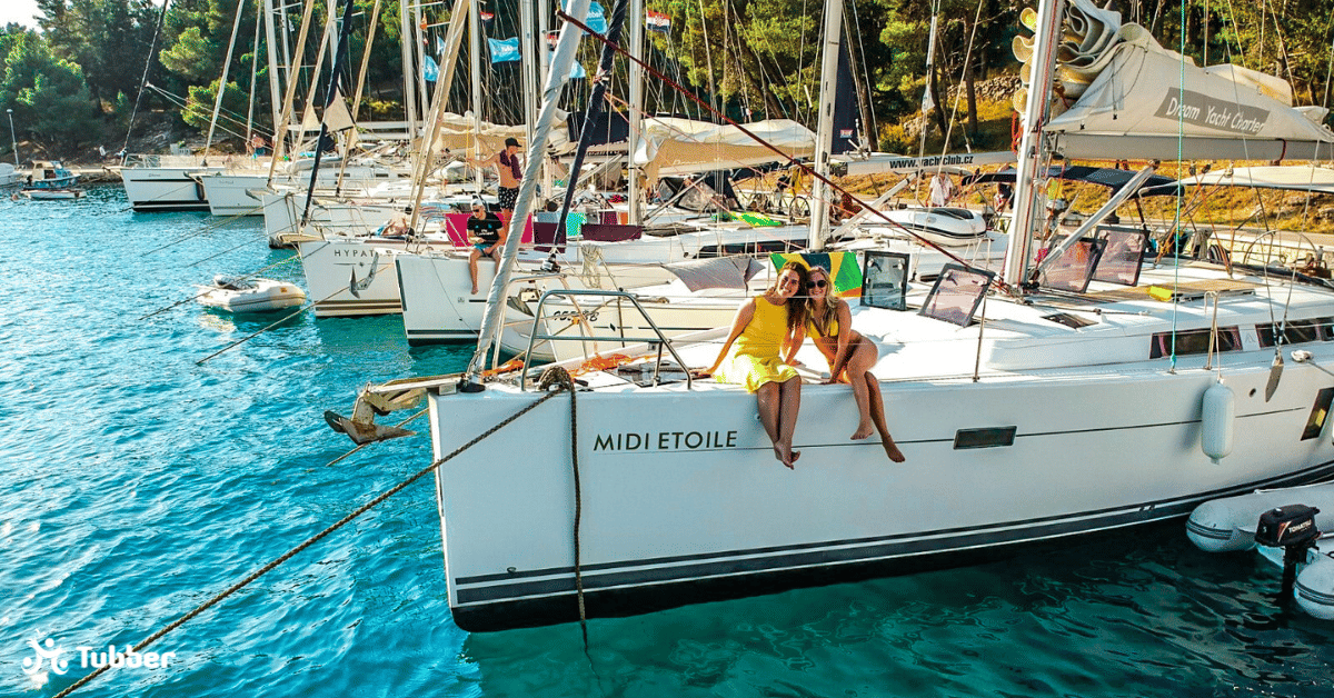 Zwei Frauen in gelber Kleidung die auf einer Yacht sitzen.