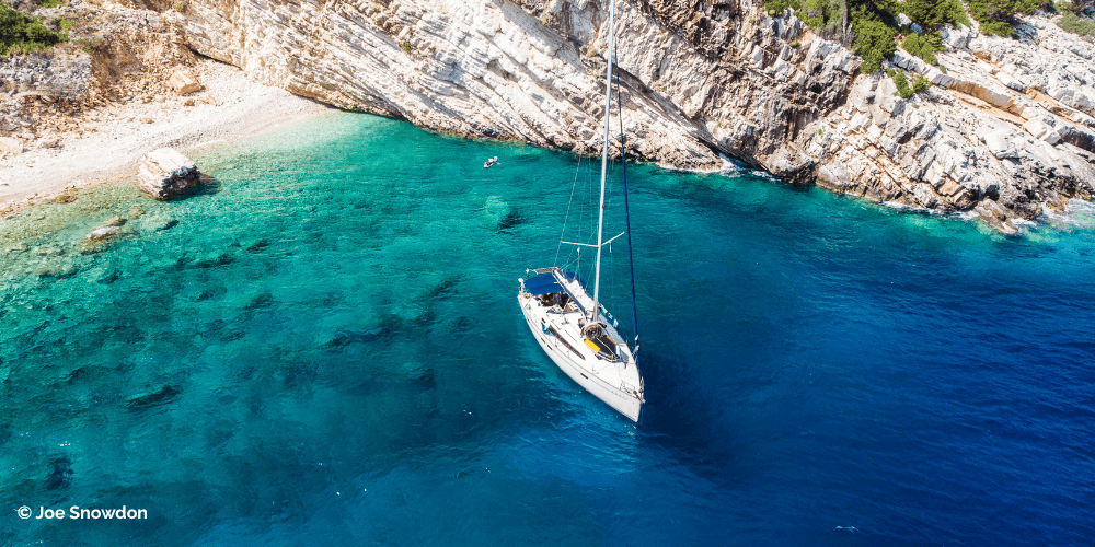 Iate à vela numa baía com águas cristalinas